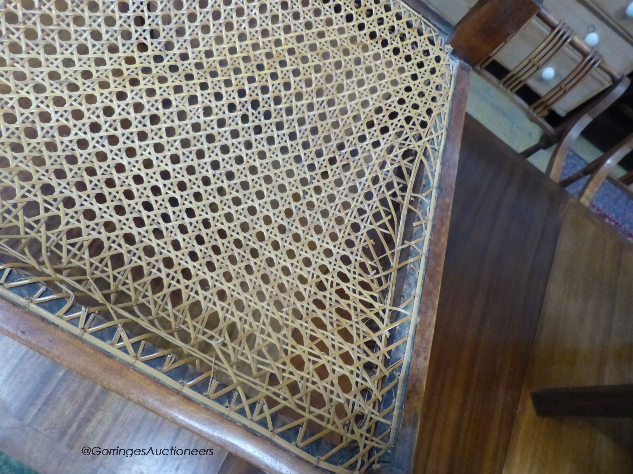 A reproduction mahogany twin pillar extending dining table and a set of six Regency fruitwood caned seated elbow chairs